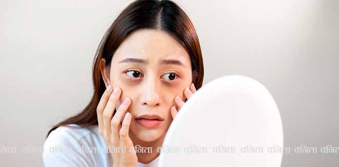 2107821761 Sleepless Asian woman looking her face in the mirror and worry about dark circles under eyes