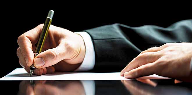 Businessman writing a letter, notes or correspondence or signing a document or agreement, close up view of his hand and the paper