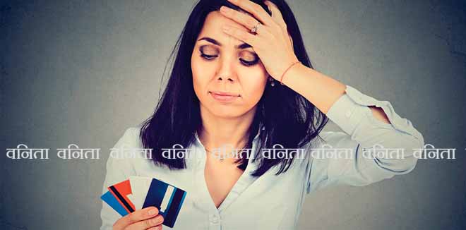 675237853 Stressed woman in debt looking at multiple credit cards isolated on gray background