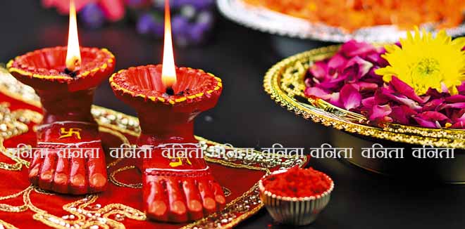 Clay Lamp Known As Diya, Deep, Diyo, Deepa Or Deepam WIth Goddess Feet Lakshmi Charan Illuminating On Red Cloth Asan With Roli Sindoor Flowers And Bokeh Effect. Shubh Deepawali And Laxmi Pooja Theme